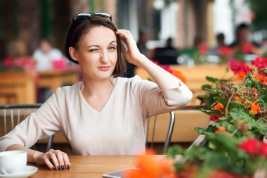 Genç kadın içecekler kahve kafeterya ve güneş gözlüğü ile poz