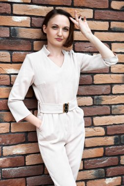 Genç kız kahverengi tuğla duvar sokakta, ayakta