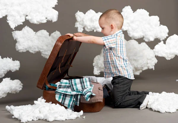 Αγόρι Κάθεται Μια Βαλίτσα Και Πηγαίνει Ένα Ταξίδι Σύννεφα Βαμβάκι — Φωτογραφία Αρχείου