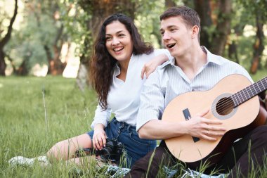 ormanda yürüyüş ve fotoğrafta eski fotoğraf makinesi, yaz doğa, parlak güneş ışığı, gitar, çalmak genç çift gölgeler ve yeşil yaprakları, romantik duygular