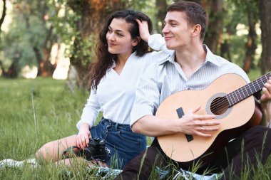 ormanda yürüyüş ve fotoğrafta eski fotoğraf makinesi, yaz doğa, parlak güneş ışığı, gitar, çalmak genç çift gölgeler ve yeşil yaprakları, romantik duygular
