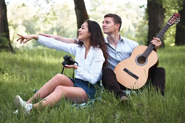 ormanda yürüyüş ve fotoğrafta eski fotoğraf makinesi, yaz doğa, parlak güneş ışığı, gitar, çalmak genç çift gölgeler ve yeşil yaprakları, romantik duygular