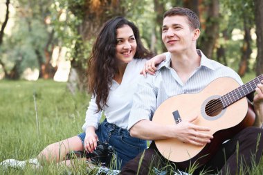 ormanda yürüyüş ve fotoğrafta eski fotoğraf makinesi, yaz doğa, parlak güneş ışığı, gitar, çalmak genç çift gölgeler ve yeşil yaprakları, romantik duygular