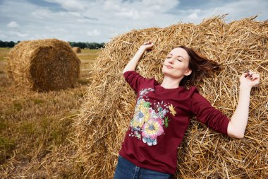Genç kız eğleniyor alanında bir haystack yalan