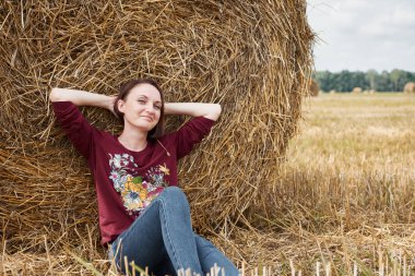 Genç kız alan, eğleniyor oturur bir samanlıkta ve rahatlatıcı