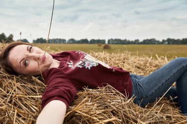 Genç kız eğleniyor alanında bir haystack yalan