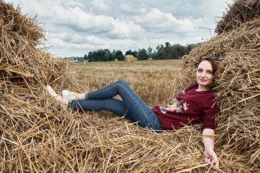 Genç kız eğleniyor alanında bir haystack yalan