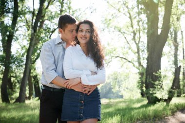 Genç çift, orman, yaz doğa, parlak güneş ışığı yürüyüş gölgeler ve yeşil yaprakları, romantik duygular