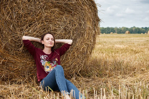 Genç kız alan, eğleniyor oturur bir samanlıkta ve rahatlatıcı
