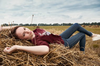 Genç kız eğleniyor alanında bir haystack yalan