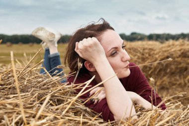 Genç kız eğleniyor alanında bir haystack yalan