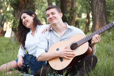 ormanda yürüyüş ve fotoğrafta eski fotoğraf makinesi, yaz doğa, parlak güneş ışığı, gitar, çalmak genç çift gölgeler ve yeşil yaprakları, romantik duygular