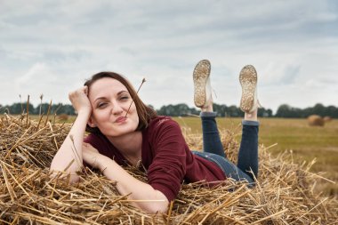 Genç kız eğleniyor alanında bir haystack yalan