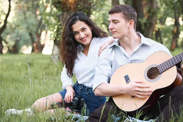 ormanda yürüyüş ve fotoğrafta eski fotoğraf makinesi, yaz doğa, parlak güneş ışığı, gitar, çalmak genç çift gölgeler ve yeşil yaprakları, romantik duygular