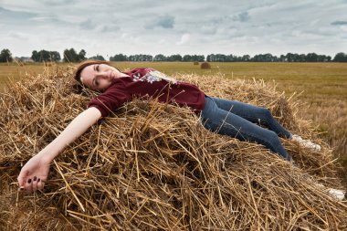 Genç kız eğleniyor alanında bir haystack yalan