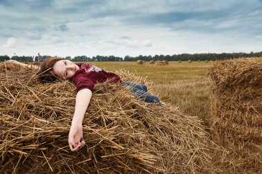 Genç kız eğleniyor alanında bir haystack yalan