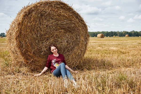 Genç kız alan, eğleniyor oturur bir samanlıkta ve rahatlatıcı