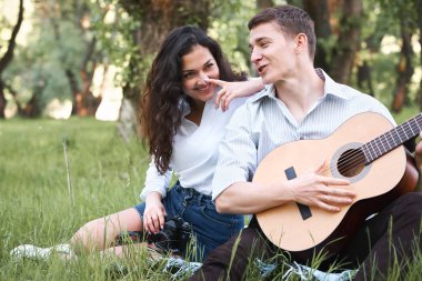 ormanda yürüyüş ve fotoğrafta eski fotoğraf makinesi, yaz doğa, parlak güneş ışığı, gitar, çalmak genç çift gölgeler ve yeşil yaprakları, romantik duygular