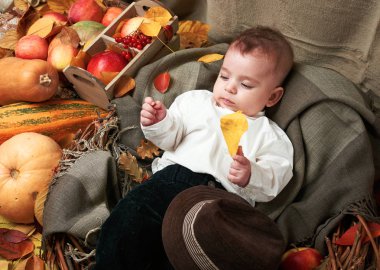 Sonbahar kavramı - çocuk çocuk yalan meyve ve vegatbles, kırmızı elma ve kabak sarı yapraklarda