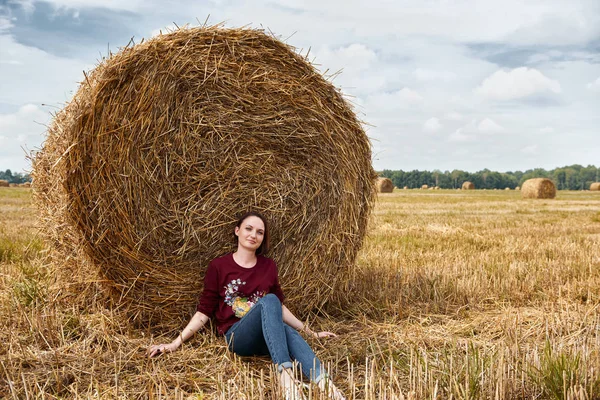 Genç kız alan, eğleniyor oturur bir samanlıkta ve rahatlatıcı