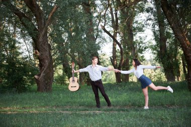 ormanda yürüyüş ve iskambil gitar, yaz doğa, parlak güneş ışığı genç çift, gölgeler ve yeşil yaprakları, romantik duygular