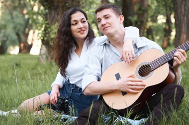 ormanda yürüyüş ve fotoğrafta eski fotoğraf makinesi, yaz doğa, parlak güneş ışığı, gitar, çalmak genç çift gölgeler ve yeşil yaprakları, romantik duygular