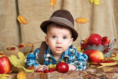 Sonbahar kavramı - çocuk çocuk yalan meyve ve vegatbles, kırmızı elma ve kabak sarı yapraklarda