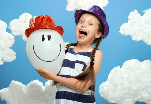 Κορίτσι Ντυμένος Ριγέ Φόρεμα Και Χρώμα Καπέλο Θέτοντας Μπλε Φόντο — Φωτογραφία Αρχείου