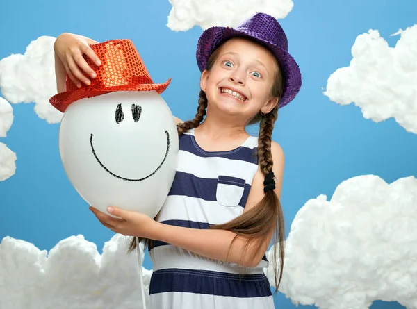 Κορίτσι Ντυμένος Ριγέ Φόρεμα Και Χρώμα Καπέλο Θέτοντας Μπλε Φόντο — Φωτογραφία Αρχείου