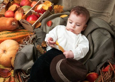 Sonbahar kavramı - çocuk çocuk yalan meyve ve vegatbles, kırmızı elma ve kabak sarı yapraklarda