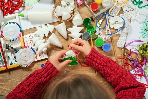 Childrens making decorations for new year holiday. Painting watercolors. Top view. Artwork workplace with creative accessories.