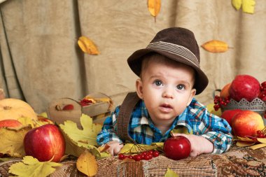 Sonbahar kavramı - çocuk çocuk yalan meyve ve vegatbles, kırmızı elma ve kabak sarı yapraklarda