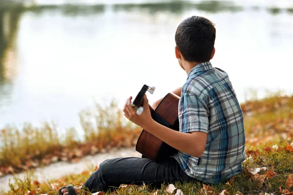Хлопчик Грає Акустичної Гітари Розташований Березі Річки Осінній Ліс Захід — стокове фото