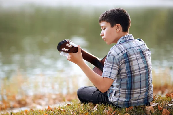 Jongen Een Akoestische Gitaar Speelt Zit Aan Oever Van Rivier — Stockfoto