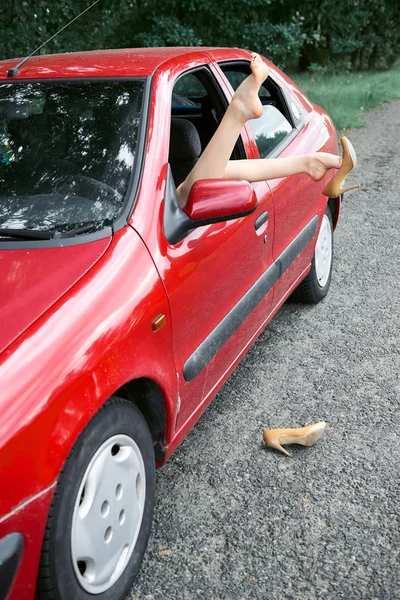 車の窓 幸せな旅行の概念 女性の高いヒールの靴に足を置く 赤い車で休んで若い女性ドライバーが黄色 — ストック写真