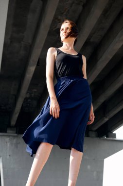 Genç kız köprünün altında poz giyinmiş siyah, modern mimari