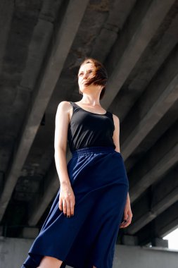 Genç kız köprünün altında poz giyinmiş siyah, modern mimari