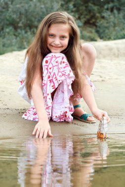 nehirde gemi yelken bir oyuncakla oynayan kız