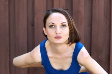 Genç kız kırmızı kahverengi ahşap arka plan üzerinde mavi uzun elbise poz