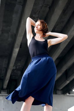 Genç kız köprünün altında poz giyinmiş siyah, modern mimari