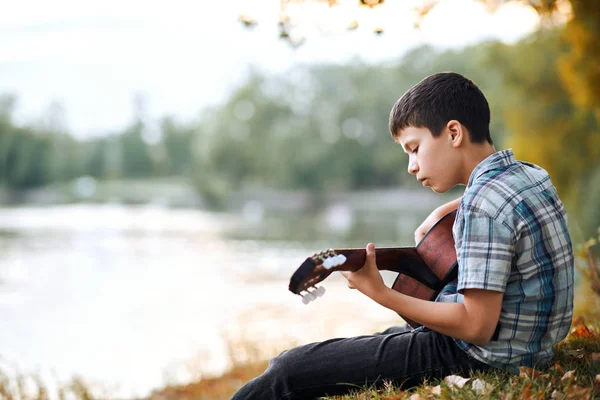 Jongen Een Akoestische Gitaar Speelt Zit Aan Oever Van Rivier — Stockfoto