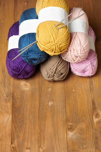 在木背景上编织的五颜六色的羊毛线 — 图库照片