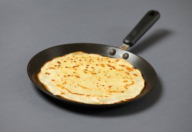 Krep closeup, kızartma tavası, gri arka plan üzerinde ince gözleme