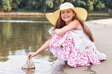 nehirde gemi yelken bir oyuncakla oynayan kız