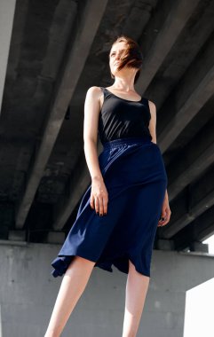 Genç kız köprünün altında poz giyinmiş siyah, modern mimari