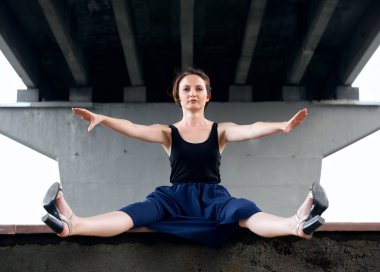 Genç kız köprünün altında poz giyinmiş siyah, modern mimari