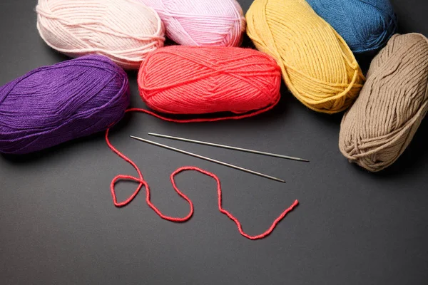 balls of woolen thread for knitting on black background