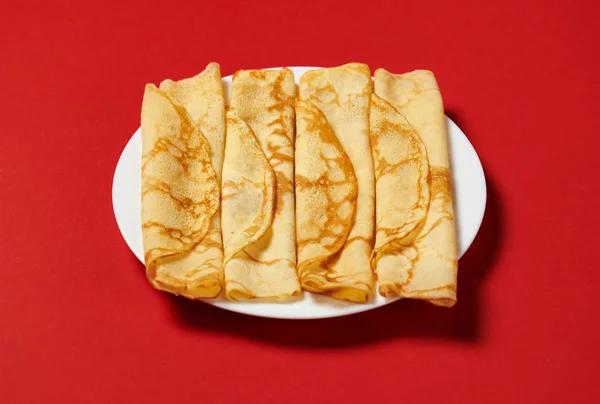 クレープ クローズ アップ 赤の背景に薄いパンケーキのヒープ — ストック写真