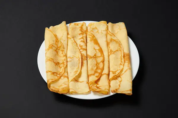 クレープ クローズ アップ 黒の背景に薄いパンケーキのヒープ — ストック写真