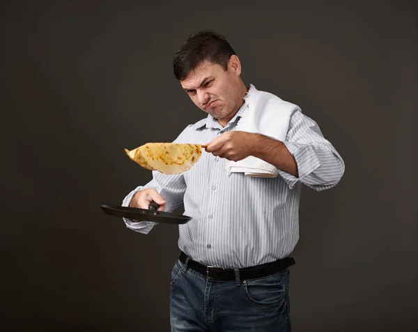 Uomo Posa Con Pancake Una Padella Camicia Bianca Pantaloni Sfondo — Foto Stock